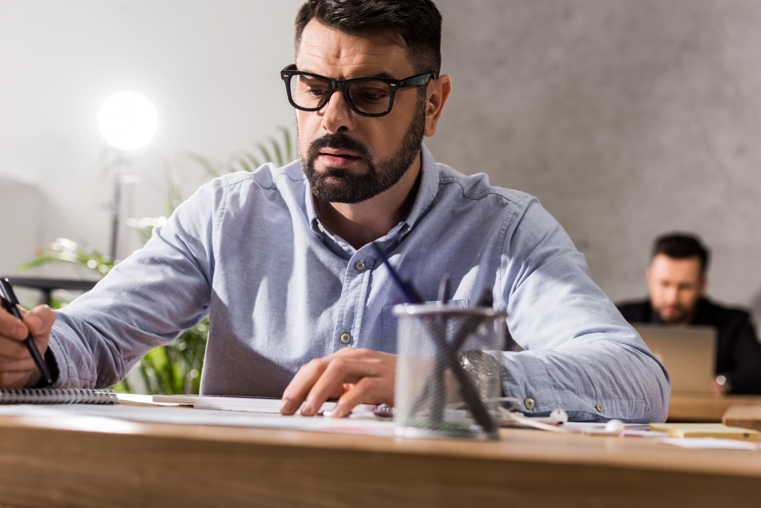 handsome businessman writing something to notebook at working table